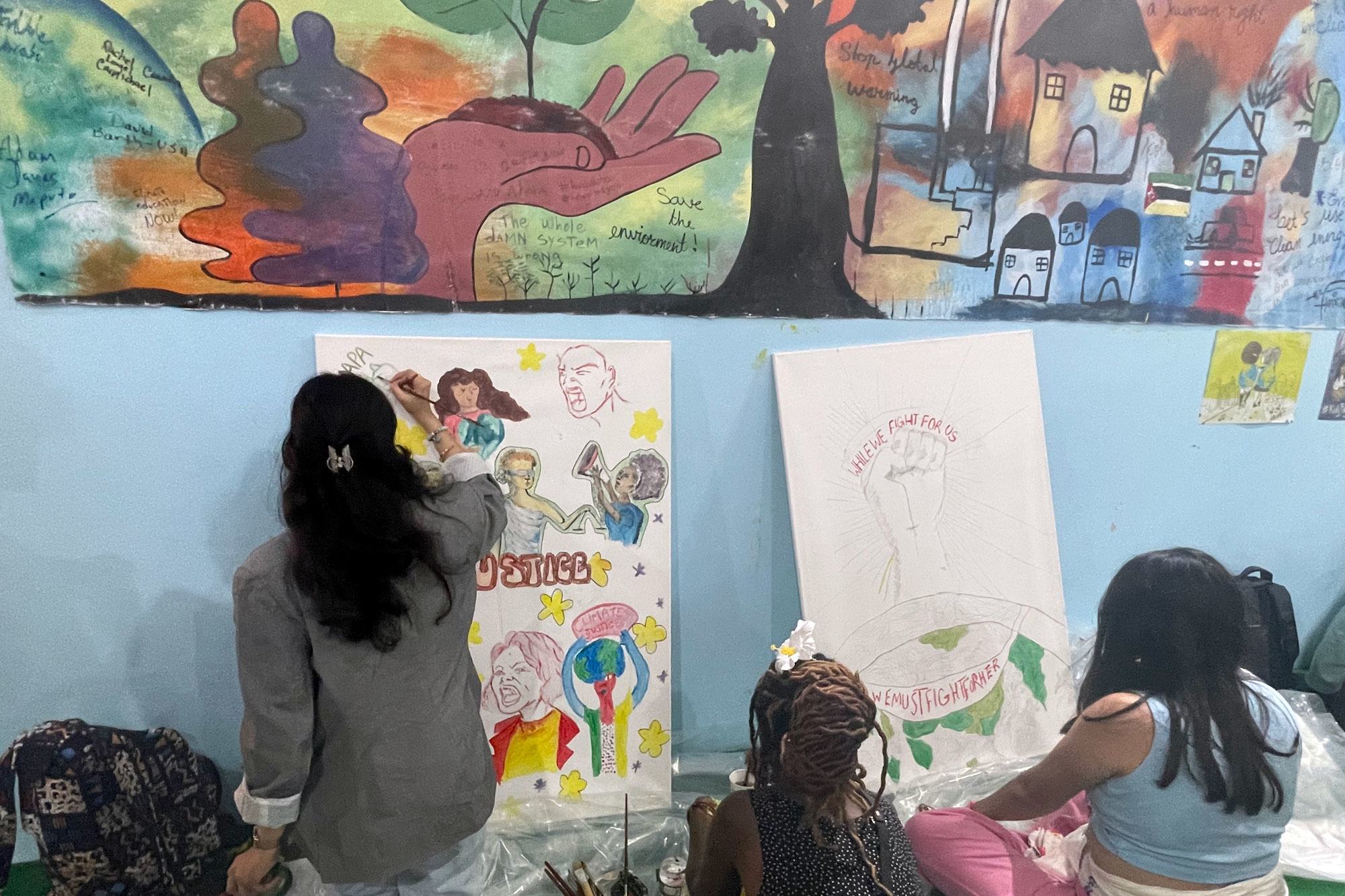 آیشکا نجیب، مدافع جوانان یونیسف، یک اثر هنری مشترک در غرفه جوانان نقاشی می کند.